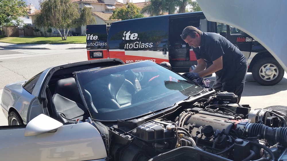 auto technicians replacing glass on a c4, photograph by PLRX